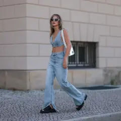 Stylowa kobieta w jeansach bootcut z rozcięciami i denimowym topie, prezentująca letnią modę.