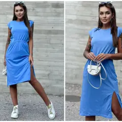 Kobieta w niebieskiej sukience i białych sneakersach. Idealne połączenie, jeśli zastanawiasz się, jakie buty do niebieskiej sukienki pasują na co dzień.