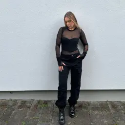 Stylizacja na koncert: czarny, prześwitujący top, bojówki i glany. Idealny outfit na imprezę.