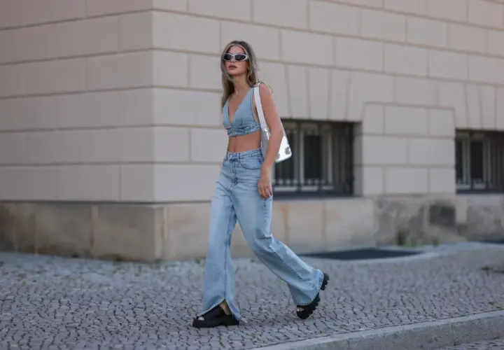 Stylowa kobieta w jeansach bootcut z rozcięciami i denimowym topie, prezentująca letnią modę.