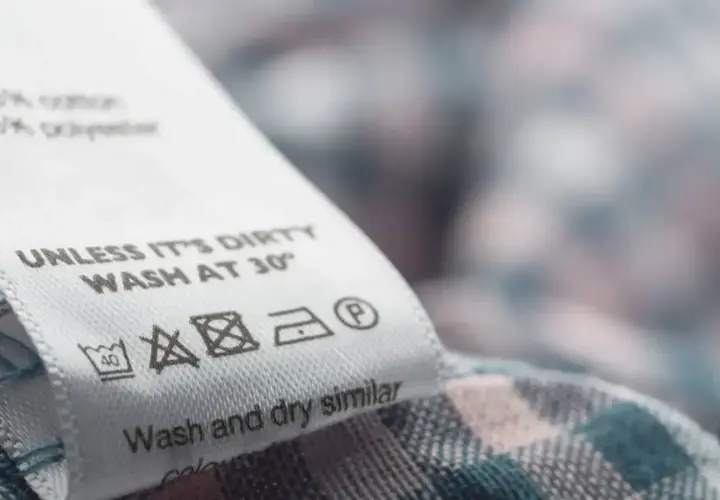 Metka z instrukcją prania: "UNLESS IT'S DIRTY WASH AT 30°". Podpowiada, z jakich materiałów kupować ubrania, by służyły dłużej.